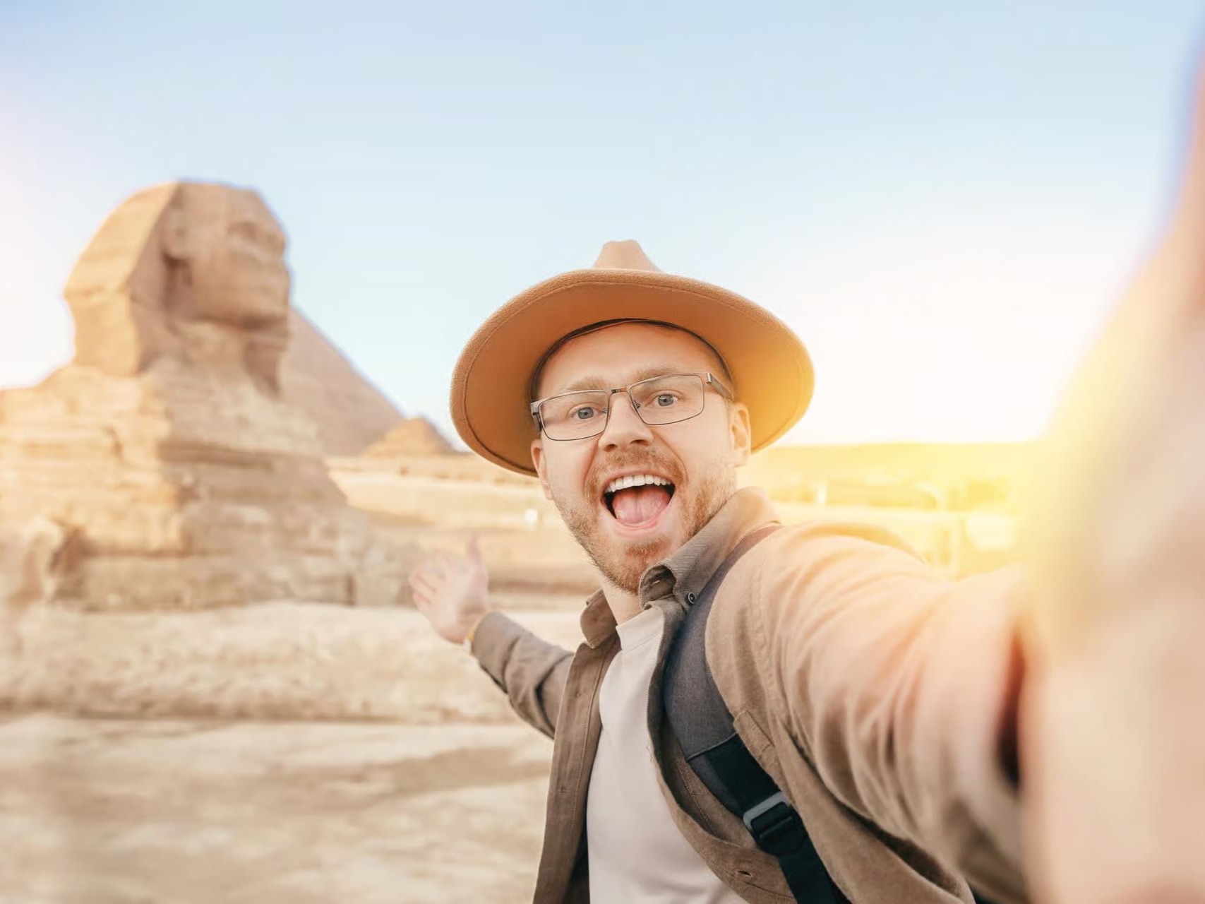 Visitor taking a selfie with the Pyramids and Sphinx