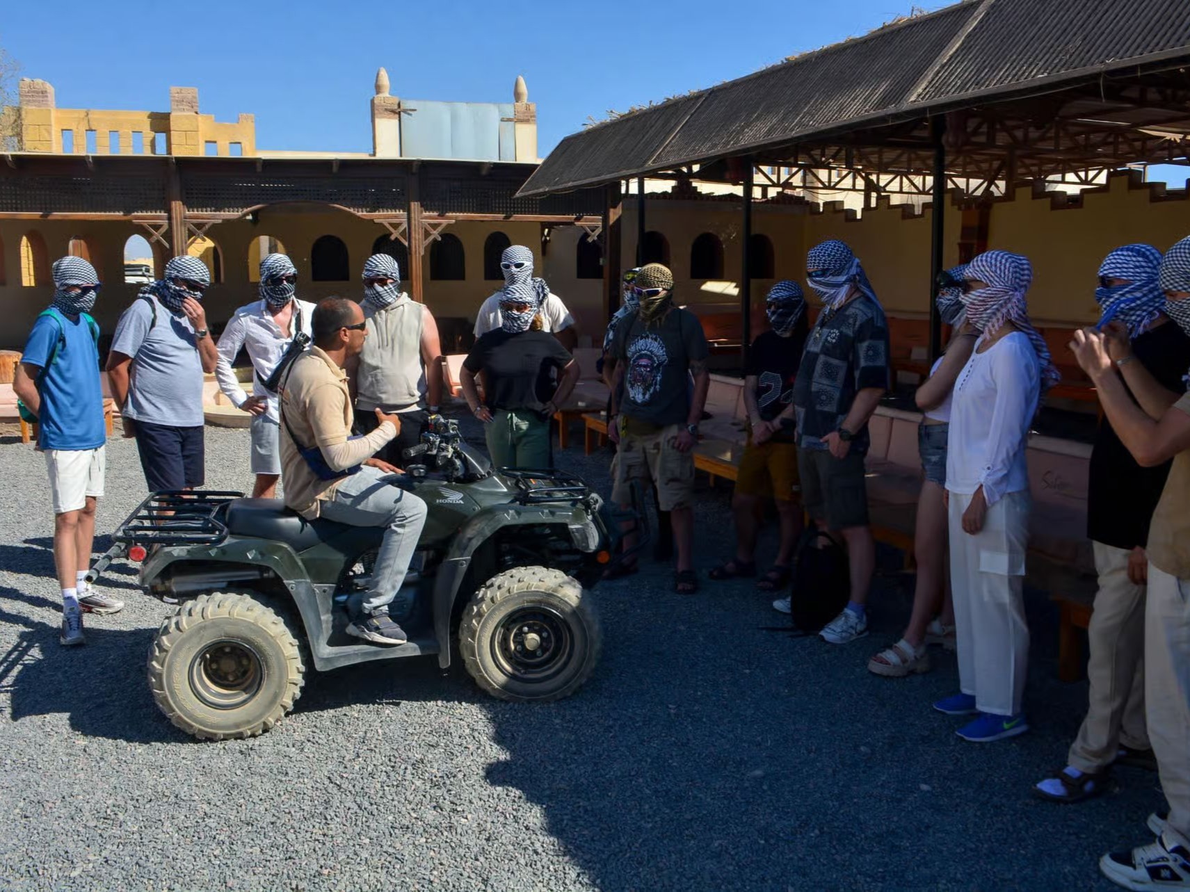 Guests on a red quad bike in the desert