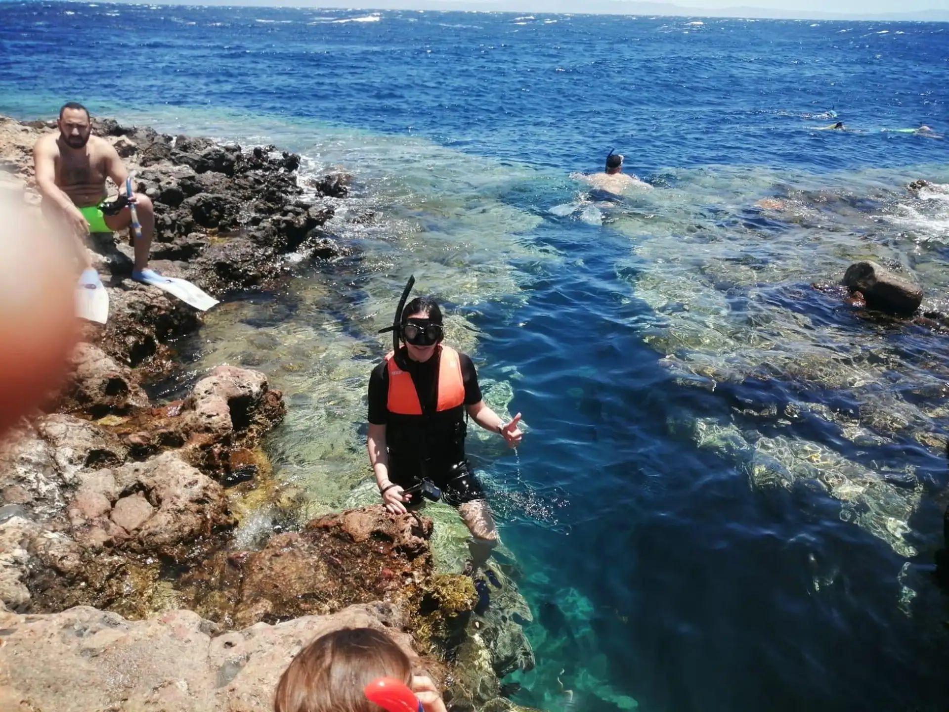 Guest entering the sea at a rocky shoreline